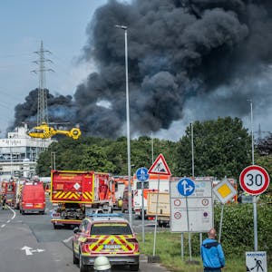 Feuerwehr, Rettungsfahrzeuge und ein Hubschrauber sind nach der Explosion in Bürrig vor der stark qualmenden Sondermüllverbrennung zu sehen