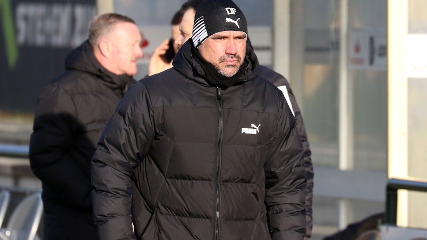 Daniel Farke, Trainer von Borussia Mönchengladbach, am 11. Januar 2023 beim Testspiel gegen Arminia Bielefeld (4:0) an der Seitenlinie. Er trägt eine dicke schwarze Winterjacke und eine schwarze Mütze mit seinen Initialen drauf und kneift die Augen von der Sonne geblendet zusammen.