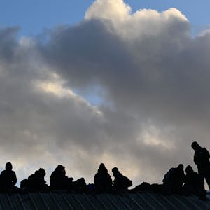11.01.2023, Nordrhein-Westfalen, Erkelenz: Demonstranten sitzen bei der Räumung des Dorfes Lützerath auf dem Giebel eines Daches.&nbsp;