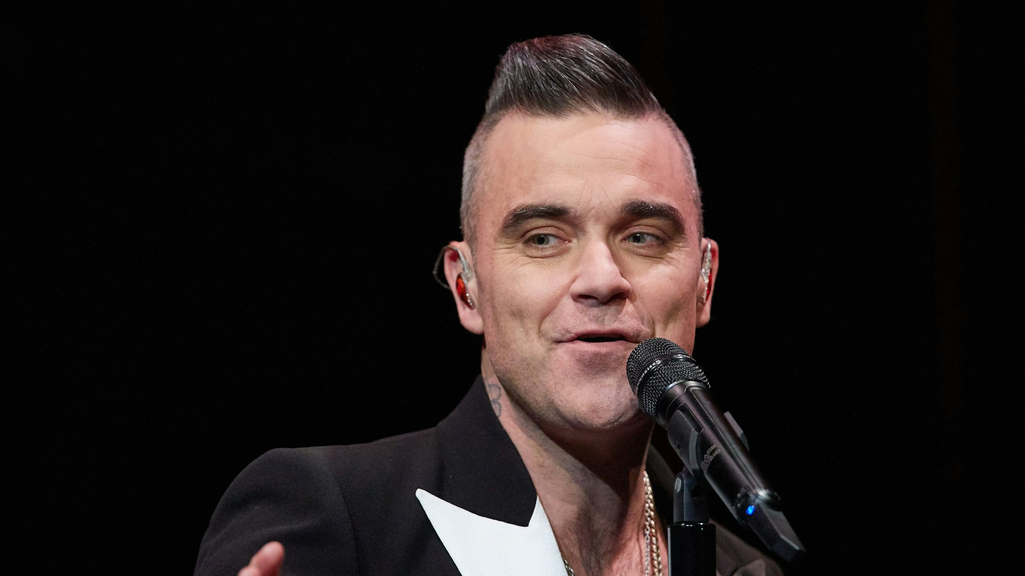 ARCHIV - 05.12.2019, Hamburg: Der englische Sänger Robbie Williams tritt während eines Konzerts im Kehrwieder Theater auf. Robbie Williams macht im Februar erneut mit mehreren Konzerten auch in Deutschland Halt.