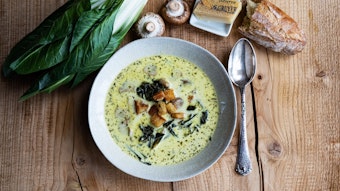 Die goldfarbene Suppe mit Croutons. Daneben frischer Mangold, braune Pilze, Gruyère und Baguettebrot.