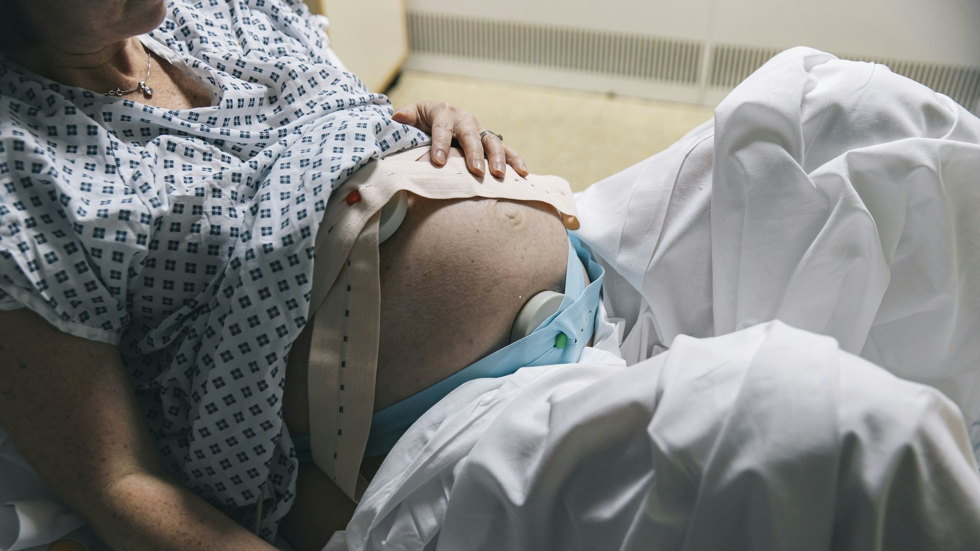 Eine unkenntliche, schwangere Frau liegt in einem Krankenhausbett.