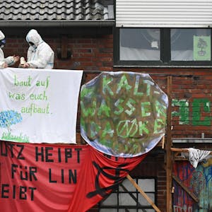 Aktivisten hängen ein Plakat auf, um gegen die Räumung von Lützerath zu protestieren.