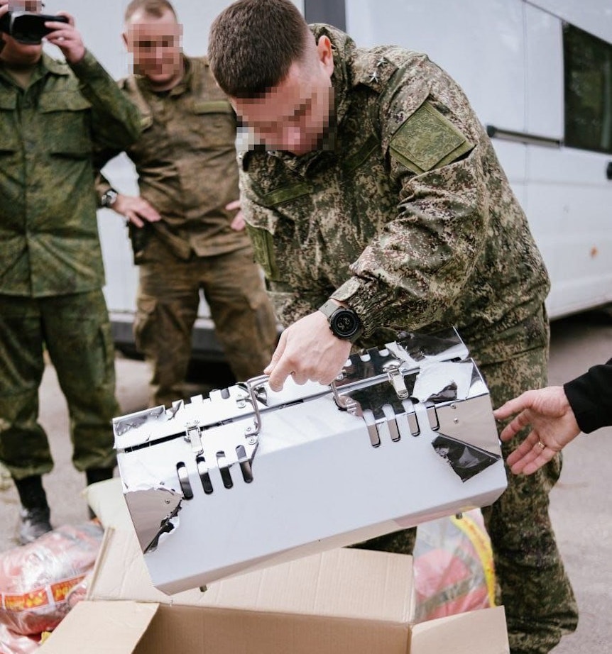 Ein russischer Soldat hebt einen neuen Heizkörper aus der Verpackung, den Kolbasnikova und Schlund gekauft haben.