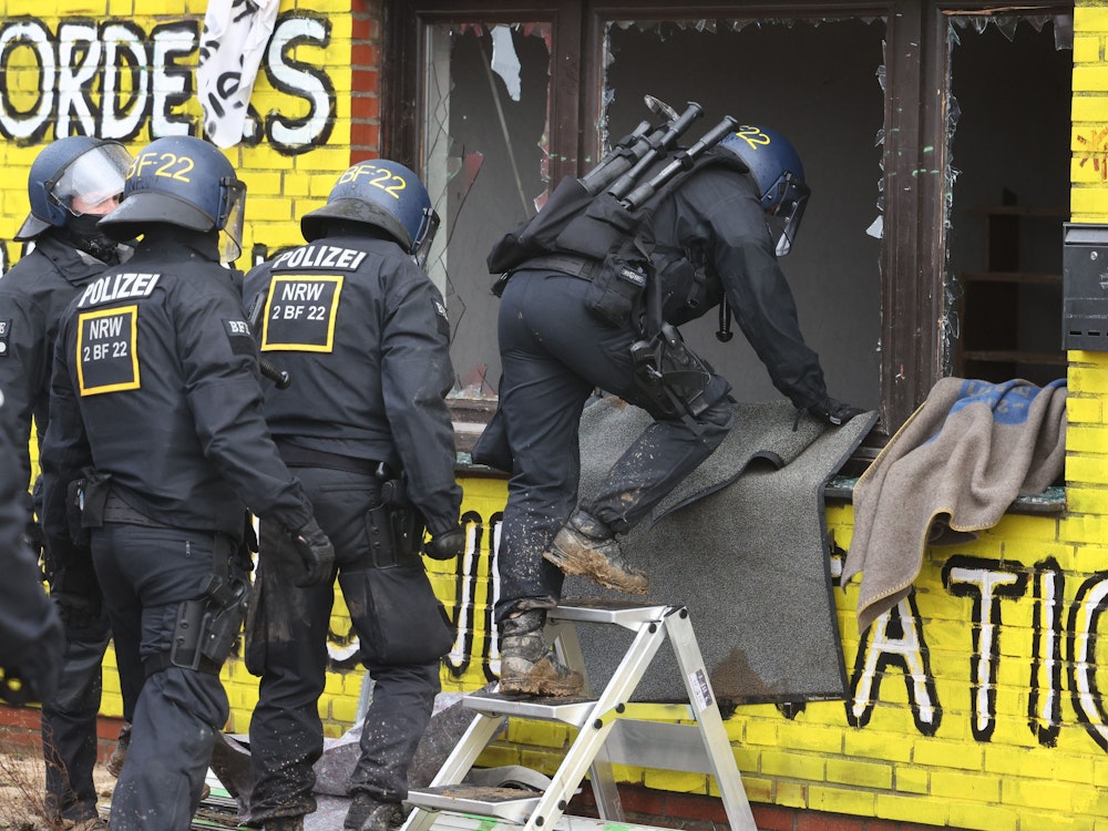 Polizisten verschaffen sich am zweiten Tag der Räumung im von Klimaaktivisten besetzten Braunkohleort Lützerath Zutritt zu einem Gebäude.