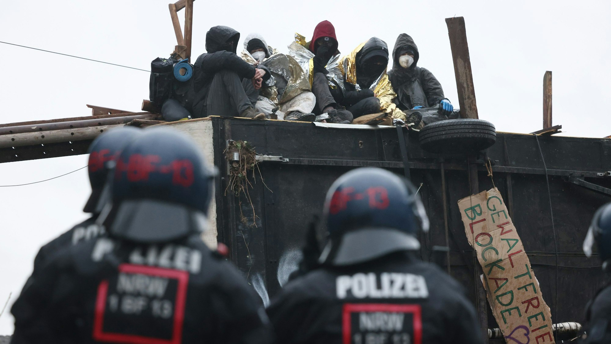 Polizisten stehen am zweiten Tag der Räumung im von Klimaaktivisten besetzten Braunkohleort Lützerath vor einer Barrikade der Aktivisten.