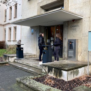 Zwei Studierende stehen vor dem Eingang der Cologne Business School.