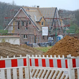 Foto einer Baustelle eines Einfamilienhauses, das noch keine Dachabdeckung hat und noch eingerüstet ist.