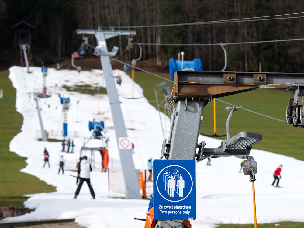 Ruhpolding: Skifahrer fahren bei schönem Wetter auf einer Skipiste. Viele Skigebiete in Bayern leiden aktuell unter Schneemangel.
