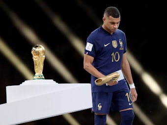 Kylian Mbappé geht nach der Ehrung zum besten Torschützen der WM 2022 von der Bühne.