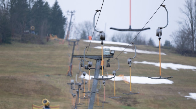 Leere Bügel hängen an einem Skilift. Nach deutlich über zehn Grad zum Jahreswechsel ist der Schnee in Ostdeutschlands Skigebieten geschmolzen.