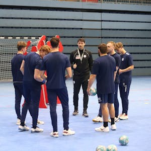 Mehrere Handballspieler des VfL Gummersbach stehen mit ihrem Co-Trainer im Kreis.&nbsp;