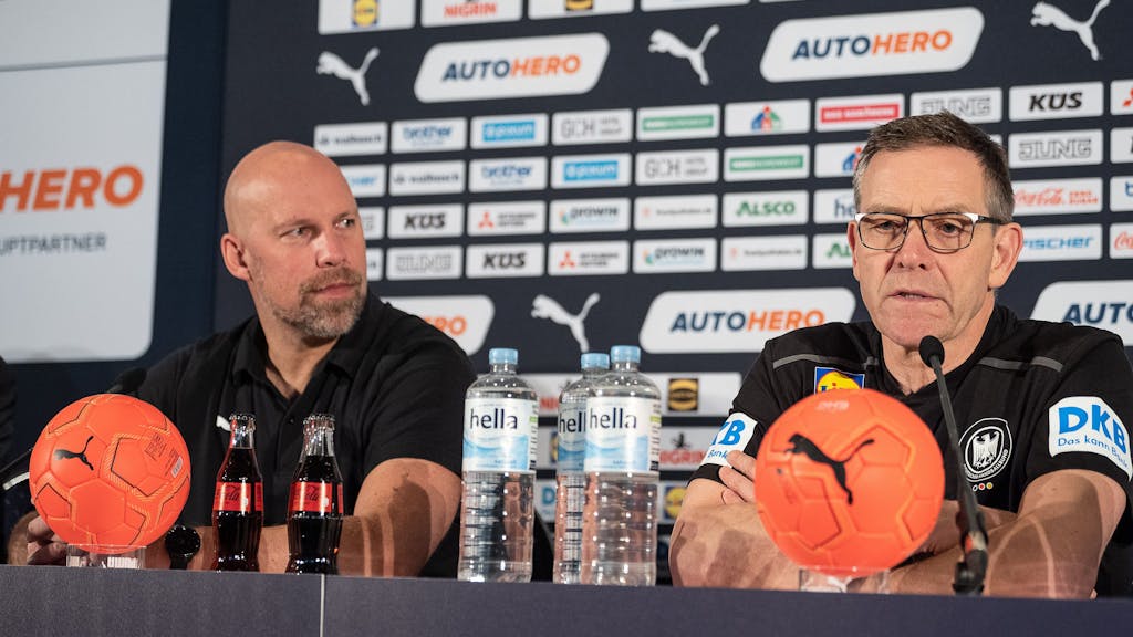 Bundestrainer Alfred Gislason (r) und Axel Kromer, Vorstand Sport beim Deutschen Handballbund, sitzen auf dem Podium.