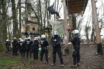 Polizisten stehen am dritten Tag der Räumung im von Klimaaktivisten besetzten Braunkohleort Lützerath vor Baumhütten der Aktivisten.