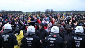 Polizisten und Klimaschützer stehen sich bei der Demonstration in Lützerath gegenüber.