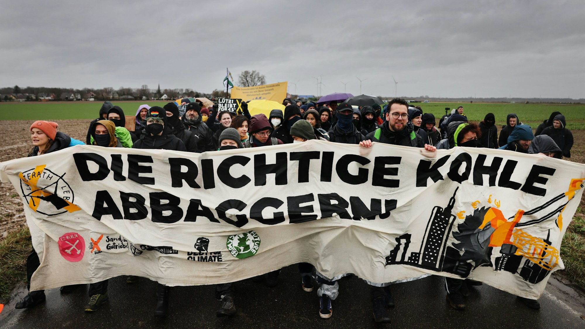 "Die richtige Kohle abbaggern" ist auf dem Transparent zu lesen, das von Demonstranten getragen wird.