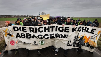 "Die richtige Kohle abbaggern" ist auf dem Transparent zu lesen, das von Demonstranten getragen wird.