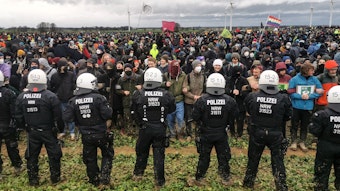 Lützerath. Polizeibeamte und Klimaschützer und Demonstrantinnen stehen sich gegenüber.