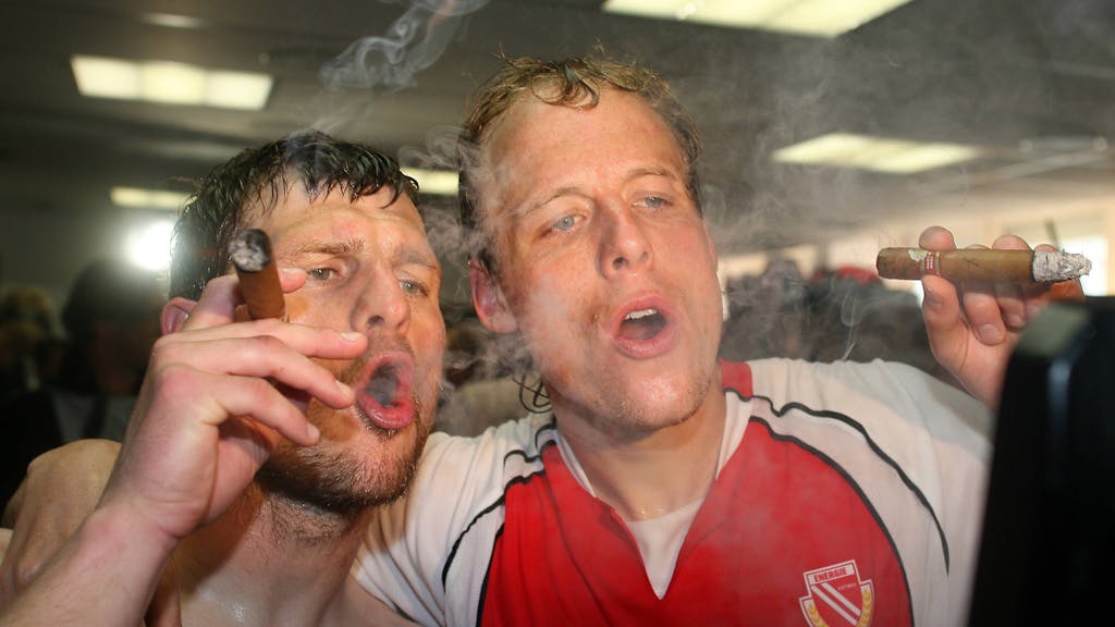Kevin McKenna (rechts) und Steffen Baumgart (beide Cottbus) gönnen sich während der Aufstiegsfeier 2006 eine Zigarre