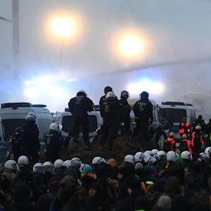 Proteste für den Erhalt Lützeraths: Eine Polizeikette schirmt am Samstag die Großdemonstration ab, die Polizei setzte Wasserwerfer, Pfefferspray und Schlagstöcke ein.