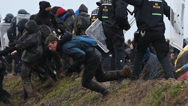 Klimaschutzaktivisten durchbrechen bei einer Demonstration gegen den Abriss des Braunkohledorfs Lützerath eine Polizeiabsperrung. Laut offiziellen Angaben wurden während der Räumung mehr als 100 Polizisten verletzt.