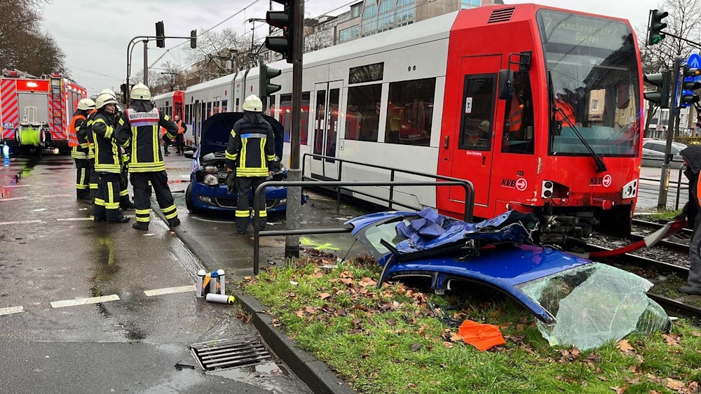 Rettungskräfte der Feuerwehr bei einem Autounfall mit einer KVB-Bahn