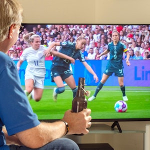 Ein Mann schaut live das Finale der Frauen Fussball-EM vor dem Fernseher.