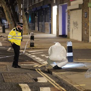 14.01.2023, Großbritannien, London: Ein Beamter der Spurensicherung arbeitet in der Nähe des Tatorts.