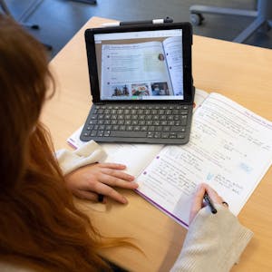 Eine Schülerin arbeitet beim Unterricht mit einem Tablet.