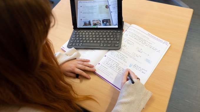 Eine Schülerin arbeitet beim Unterricht mit einem Tablet.
