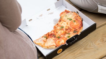 Eine halb gegessene Pizza liegt in einem Pizzakarton.