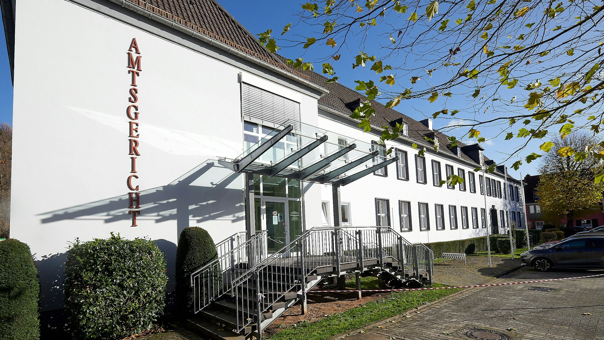 Ein Blick von außen auf das Amtsgericht in Gemünd: Das Gebäude ist weiß verputzt, vor dem Eingang sind zwei Treppen.
