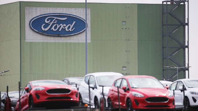 Neu gebaute Autos stehen auf Lastwagen vor dem Ford Werk.&nbsp;