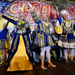 Prinz*in Clara I. (Brückers, Mitte), Bäuerin Verena (von Mengden, rechts) und Jungfrau Inga (Schoppeit) stehen auf der Bühne und jubeln.