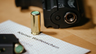 Ein kleiner Waffenschein liegt zwischen einer Schreckschuss-Pistole „Walther P22“, einem Magazin und einer Platzpatrone.