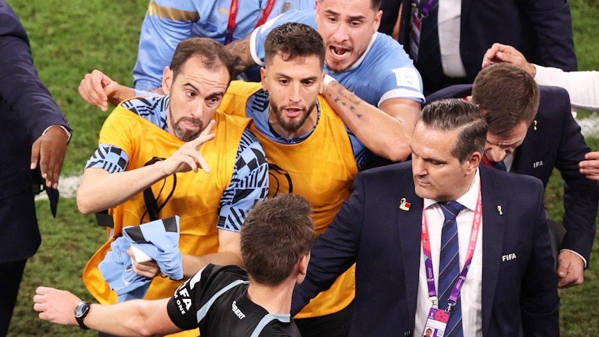 Daniel Siebert (unten) wird nach dem WM-Spiel zwischen Uruguay und Ghana von mehreren Spielern der ausgeschiedenen Südamerikaner belagert.