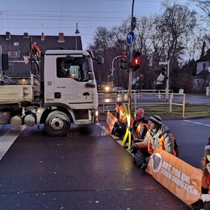 Aktivistinnen und Aktivisten der Initiative „Letzte Generation“ blockieren am Dienstagmorgen, 17. Januar, die Aachener Straße in Köln.