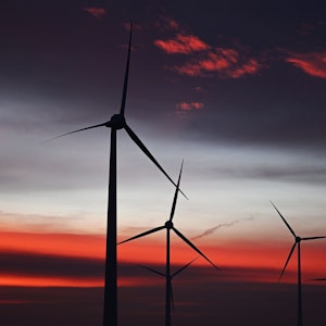 Windräder sind in einem Windpark bei Sonnenaufgang zu sehen.