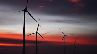 Windräder sind in einem Windpark bei Sonnenaufgang zu sehen.