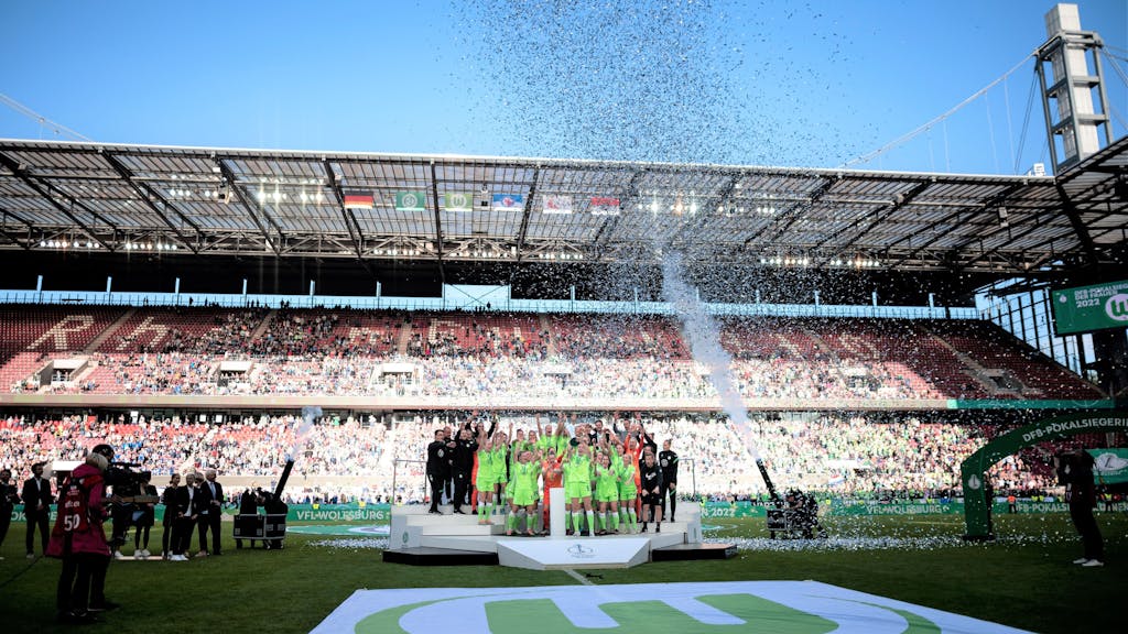 Die Spielerinnen von VfL Wolfsburg jubeln im Rhein-Energie-Stadion bei der Siegerehrung zum DFB-Pokal.