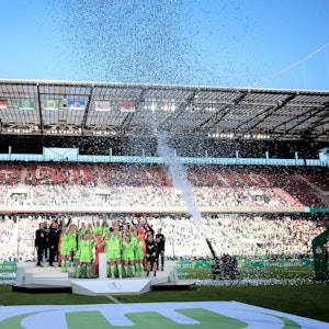 Die Spielerinnen von VfL Wolfsburg jubeln im Rhein-Energie-Stadion bei der Siegerehrung zum DFB-Pokal.