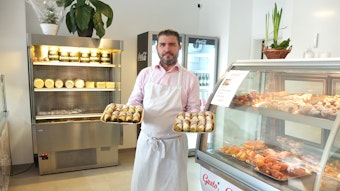 Francesco Bonfissuto mit süßen Spezialitäten in der Hand in seinem Geschäft.