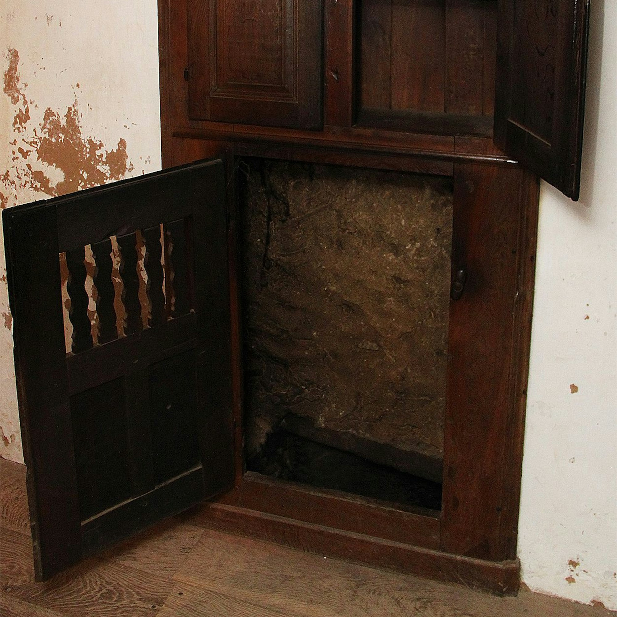 Zu sehen ist ein geöffneter Schrank, der einst der Wärmeleitung diente.