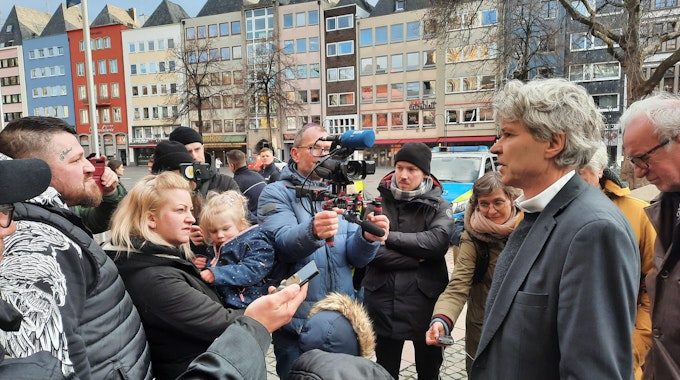 Menschen stehen um Sozialdezernent Harald Rau herum, ein Kameramann filmt ihn.&nbsp;