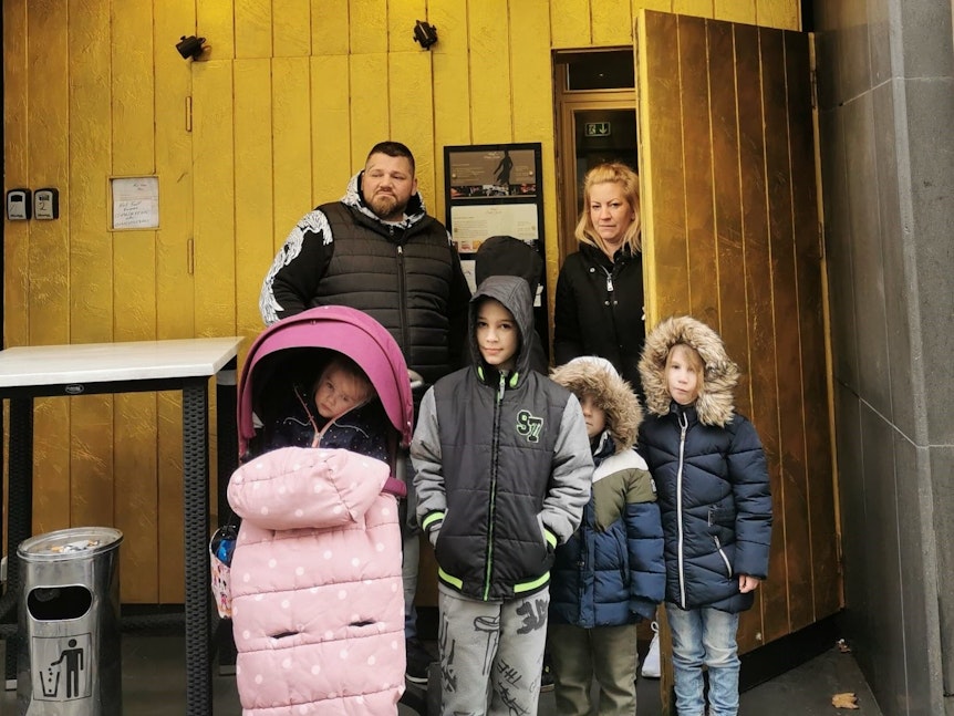 Eine Familie steht vor einer Tür.