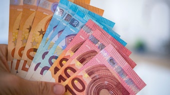Eine Frau hält Banknoten von 10, 20 und 50 Euro gefächert in der Hand.