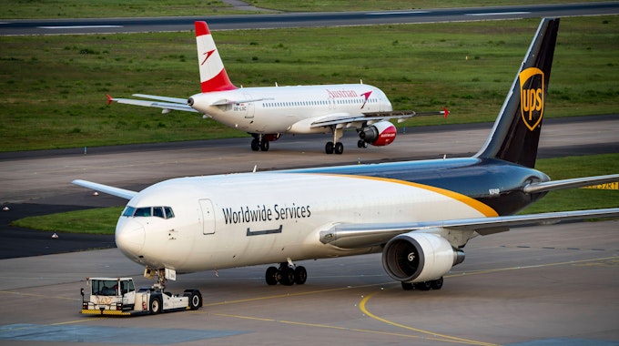 Eine Boeing 767 des Logistikunternehmens UPS am Flughafen Köln/Bonn. Im Hintergrund ist ein Flugzeug von Austrian Airlines zu sehen.