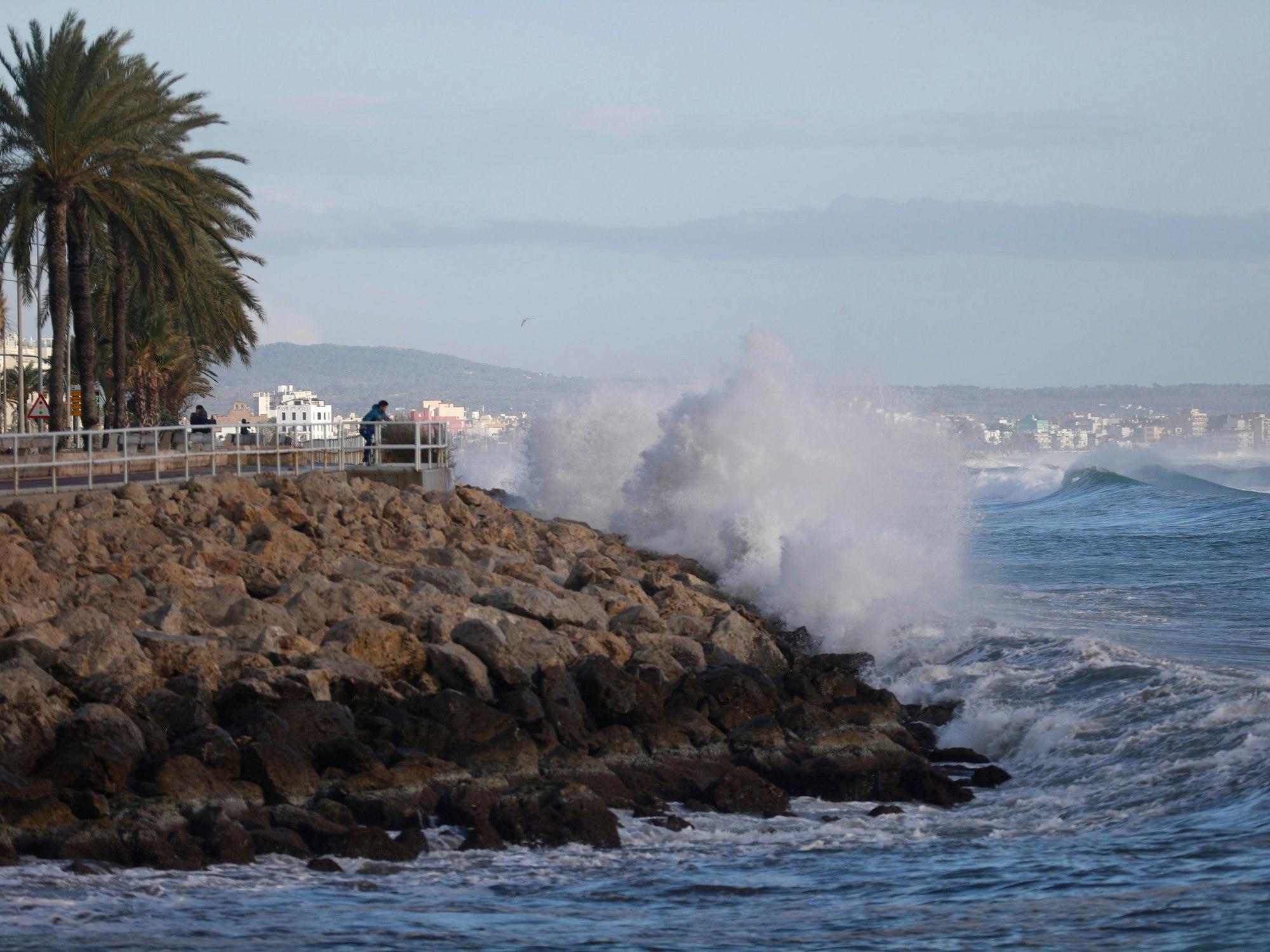 Hohe Wellen sind von der Promenade in Palma auf Mallorca aus zu sehen. Starke Winde und Regenfälle sorgen derzeit für ungemütliches Wetter auf der beliebten Urlaubsinsel. Vergangenen Dienstag (17. Januar 2023) kam deshalb eine deutsche Schwimmerin ums Leben.