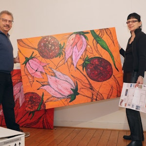 Axel Müller und Marion Menzel halten ein Gemälde im Kunstkabinett Hespert.