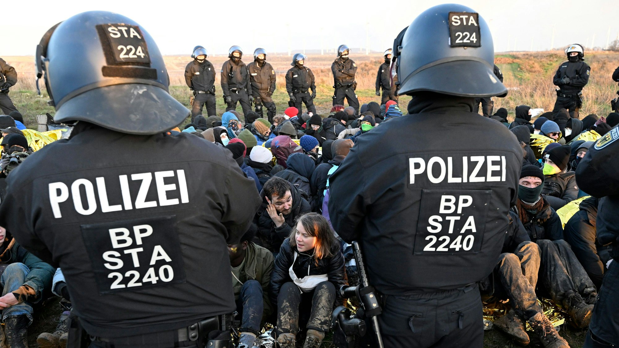 Polizisten stehen am Rand des Braunkohlentagebaus Garzweiler II am 17. Januar vor einer Gruppe von Demonstranten, darunter auch Greta Thunberg (Mitte, unten).